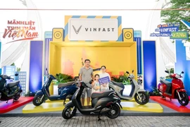 A rider exchanges his fossil fuel-powered motorbike for an electrical one at an event held by Vinfast in Hanoi. (Photo: VNA)