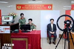 Immigration officers conduct the procedures to issue level-2 electronic identification accounts for a foreigner (Photo: VNA)